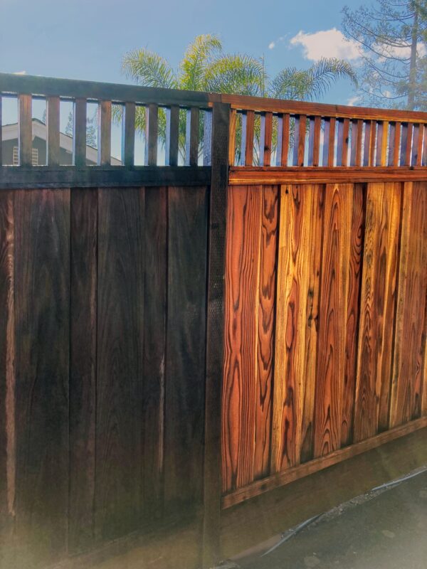 Fence panel showing dirty boards beside cleaned wood after washing